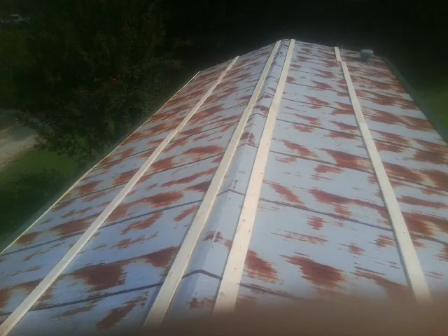 Rusted metal roof panels with new wood purlins before replacement — Storm Damage Roof Repair in Marion by Roofing Brothers